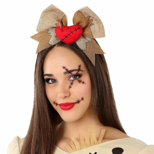 En kvinna med stygn-smink bär ett Kusligt Sött Voodoo-Diadem med en stor rosett och ett fastnålat hjärta.