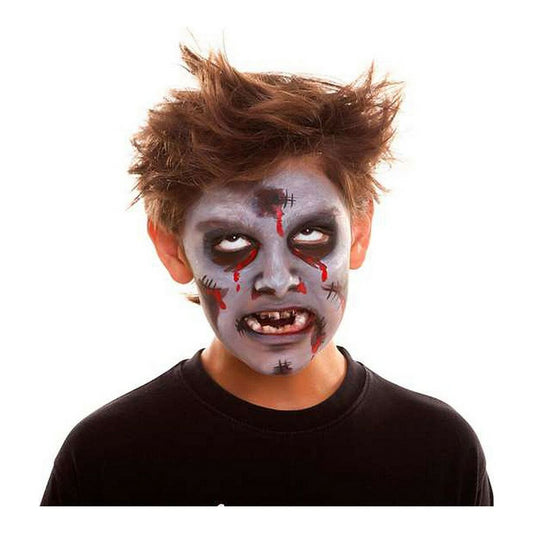En pojke med en komplett och läskig zombie-ansiktsmålning med fejk-sår och blod.