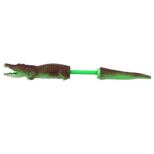 En bild som visar en vattensprutande krokodil hel och med svansen utdragen.