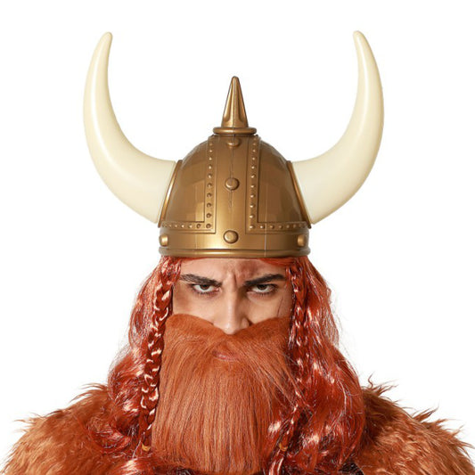 Närbild på en person med en intensiv blick som bär en mäktig, guldfärgad vikingahjälm med stora vita horn och ett yvigt rött skägg.