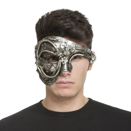 En man bär en detaljerad och sliten, silverfärgad steampunk-halvmask som täcker ena sidan av ansiktet med kugghjul och mekaniska delar.