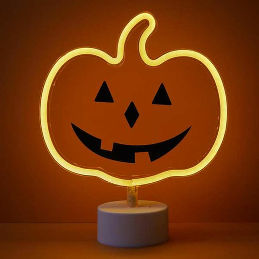 En Modern Neon Pumpa Skylt som lyser med ett varmt, orange sken på ett bord.
