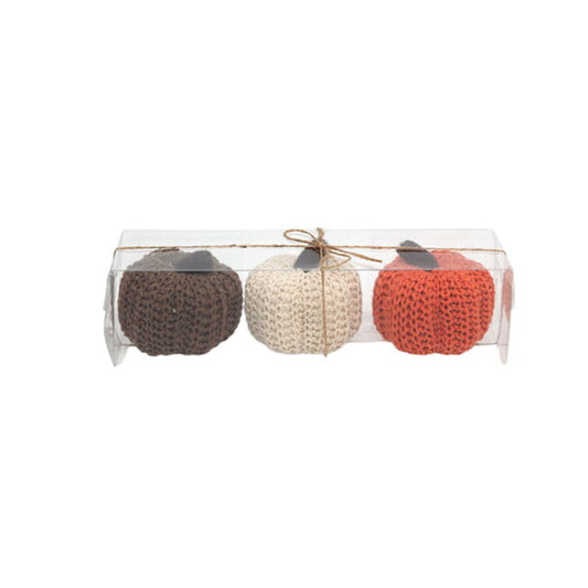 Ett 3-pack med Mysiga Virkade Dekorationspumpor i färgerna brunt, vitt och orange i sin förpackning.