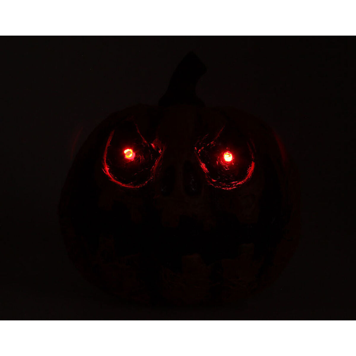 Pumpans ögon lyser med ett intensivt och skrämmande rött sken i totalt mörker.