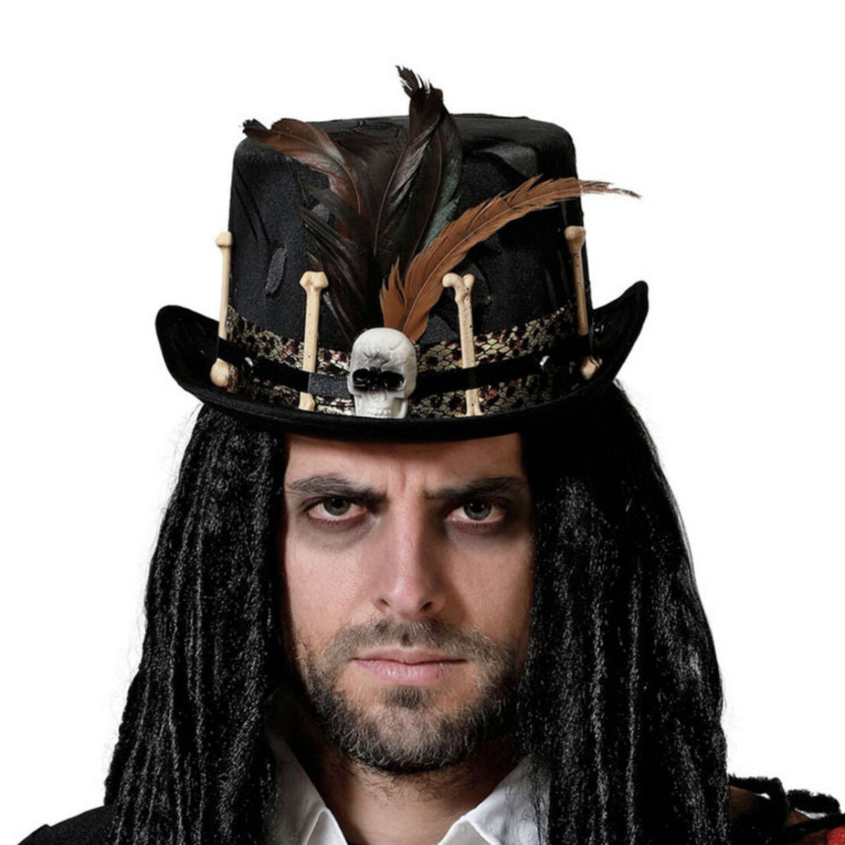 En man med mörkt sminkade ögon och dreadlocks bär en ondskefull, svart voodoo-hatt dekorerad med benknotor, fjädrar och en dödskalle.