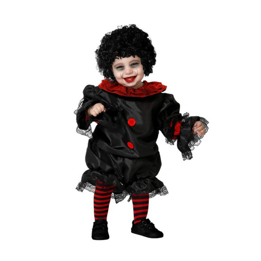 En liten bebis står utklädd till läskig clown i svart och röd dräkt med spetsdetaljer, randiga strumpbyxor och lockig svart peruk. Hen har ett brett rött leende målat på ansiktet och ser busigt glad ut.