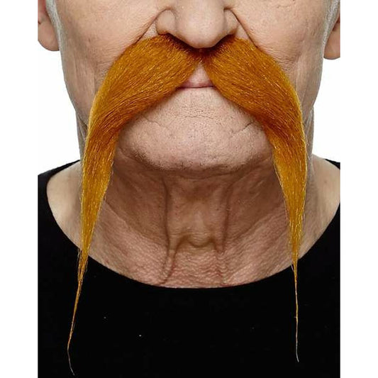 Närbild på en man som bär en stor, yvig, orange gallisk krigare-lössmustasch som hänger långt ner på sidorna av munnen, fotograferad i studio.