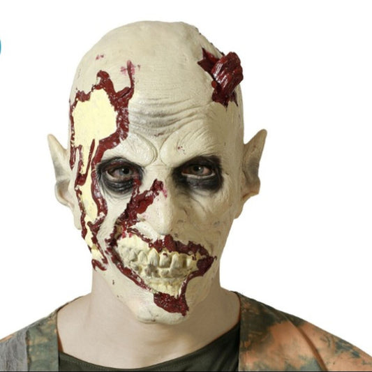 En person bär en Realistisk Ruttnande Zombiemask i latex, med blodiga sår och en blottad käke.