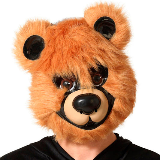 Rödbrun björnmask i fluffig plysch med ansikte och stora ögon, bärs av en person i svart tröja.