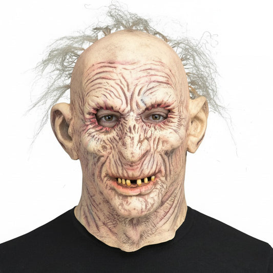 En person bär en Skrynklig Gammal Gubbe Mask i latex, med ett rynkigt ansikte, gula tänder och några hårstrån.