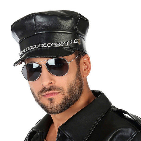 En man med skäggstubb och pilotglasögon bär en stenhård, svart biker-keps i läderimitation, komplett med en silverfärgad kedja över skärmen.
