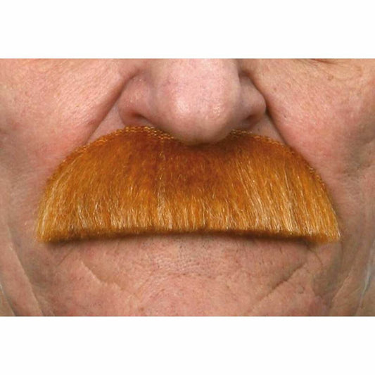 En person med en orange herrmustasch fastsatt under näsan, visandes hur accessoaren ser ut när den bärs.