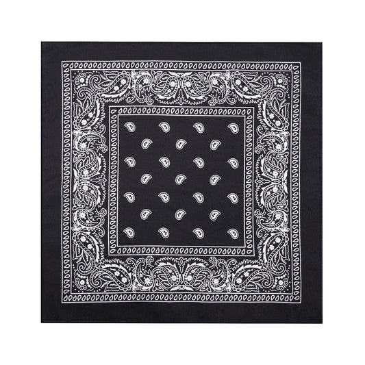 En svart bandana ligger utvikt mot vit bakgrund och visar sitt kvadratiska format, vita paisleymönster och dekorativa kant.