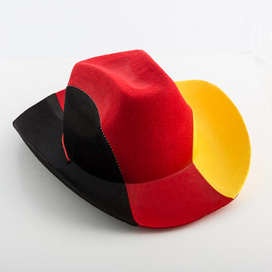 Den tysklandsfärgade cowboyhatten i filtmaterial, sedd snett framifrån på ett vitt bord.