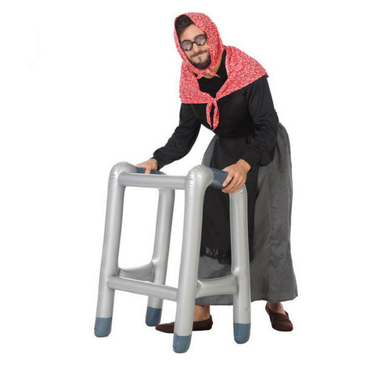 En man utklädd till en gammal dam med huckle och glasögon, som använder en uppblåsbar rullator som en rolig maskeradaccessoar.