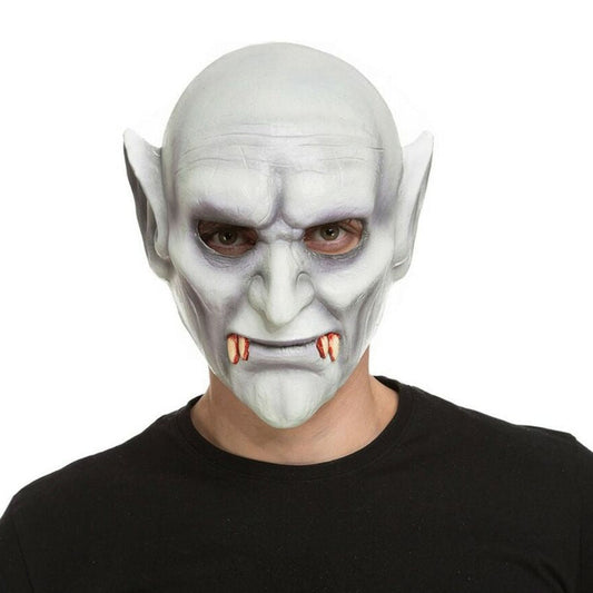 En person bär en heltäckande, gråblek Nosferatu-vampyrmask med spetsiga öron, en rynkig panna, en intensiv blick och blodiga huggtänder.