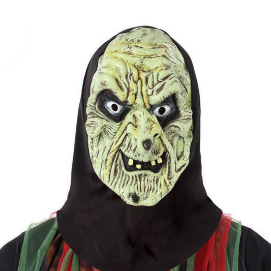 En person bär en Vidrig Grön Häxmask i latex, med ett skrynkligt ansikte, ruttna tänder och en fastsydd svart huva.
