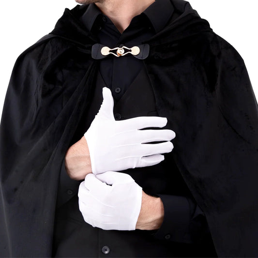 En person bär vita handskar tillsammans med svart skjorta och mantel för en elegant maskeradlook.